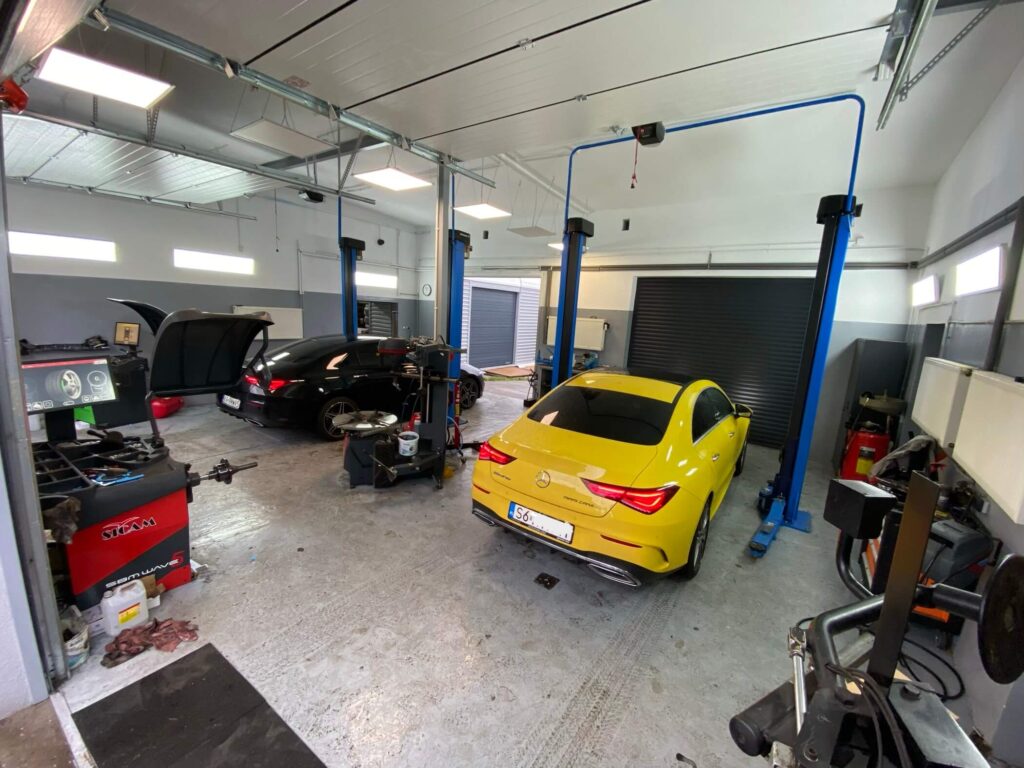 zdjęcie w tle, warsztat i dwa samochody